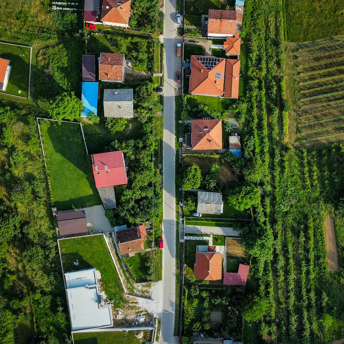 Flygvy över by i landsbygd med vägar och hus